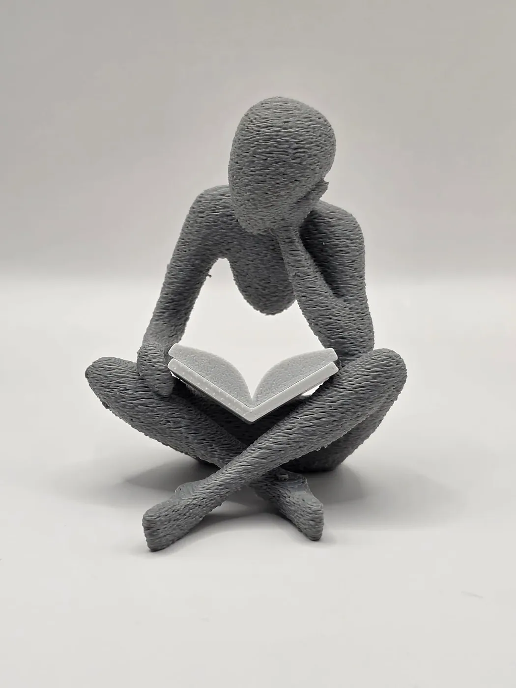 Figura lendo, peça impressa em 3D